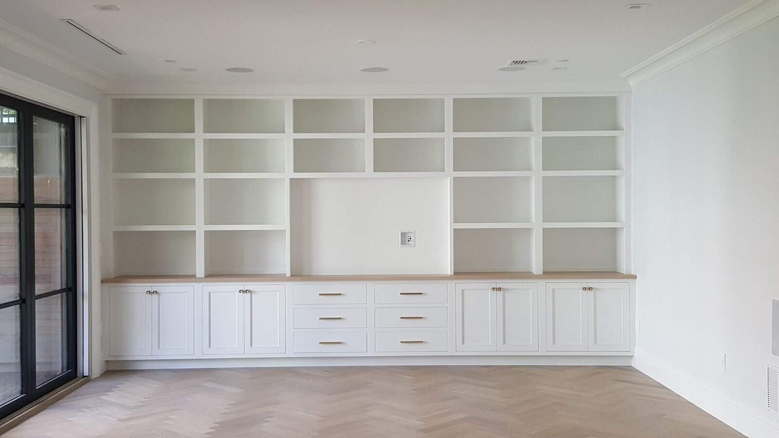 herringbone floor, steel-frame glass doors, brass hardware, wood countertop.