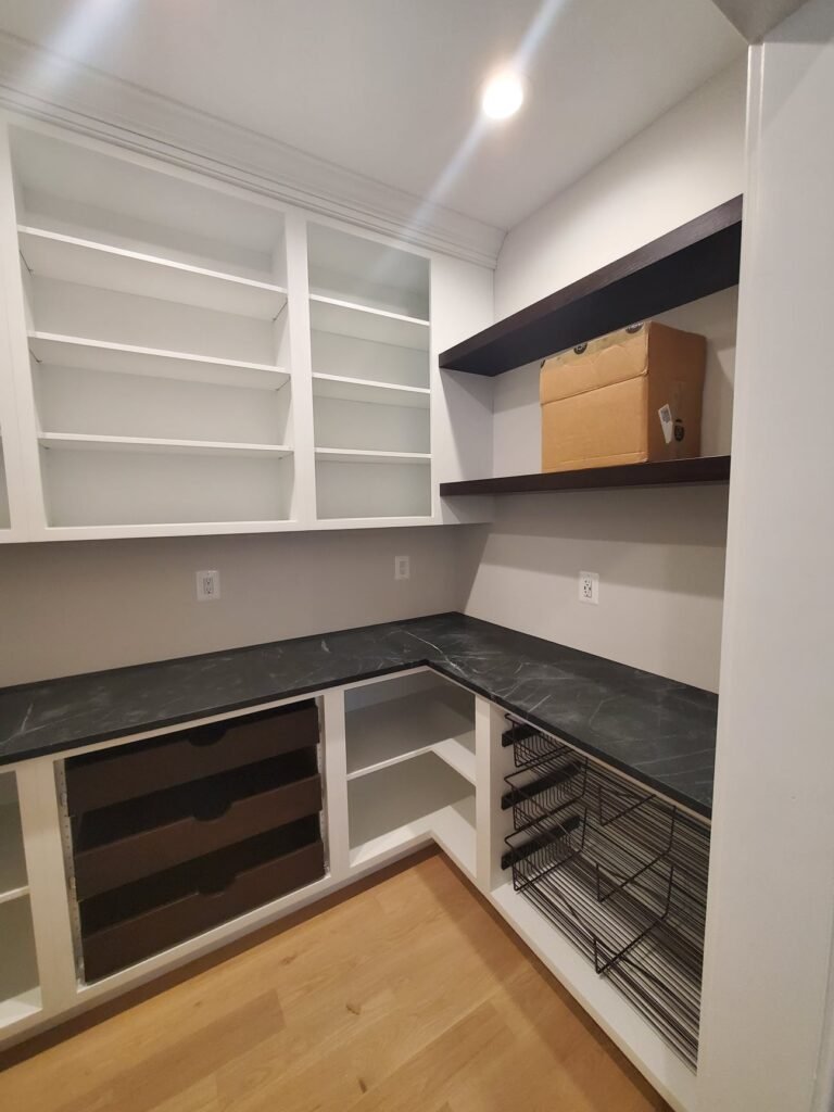 Custom Pantry Cabinets in Towson, MD — Smart Storage with Style By Choice Custom Cabinetry & Design This custom pantry in Towson, MD blends clean design with maximum functionality. Designed and built by Choice Custom Cabinetry & Design, this project showcases precision cabinetry, durable finishes, and modern organization solutions — transforming a simple corner into a highly efficient storage space. Thoughtfully Designed Custom Pantry in Towson, Maryland Every inch of this custom pantry cabinetry was carefully planned to enhance both aesthetics and practicality. The L-shaped layout maximizes the available space, while the combination of open shelving, deep drawers, and overhead cabinets provides flexible storage for everything from kitchen staples to serving dishes. A contrasting black stone countertop adds a sleek, modern look against the white built-ins, while the dark floating shelves create visual balance and depth. The result is a bright yet grounded space that ties seamlessly into the rest of the home’s design. Features of This Custom Pantry in Towson, MD Cabinetry: Handcrafted inset cabinets with soft-close drawers. Countertops: Polished black marble-look surface for durability and style. Shelving: Custom floating wood shelves for easy access and modern appeal. Lighting: Recessed LED ceiling light provides bright, shadow-free workspace. Finish: High-quality painted white finish that complements any kitchen style. Each detail in this Towson pantry project was tailored to the homeowner’s lifestyle — combining practicality with custom woodworking craftsmanship. Custom Cabinetry Across Maryland and Pennsylvania Whether you’re renovating your kitchen, creating a built-in office, or upgrading your pantry, Choice Custom Cabinetry & Design offers fully customized solutions. We proudly serve Towson, Baltimore County, Lancaster, and surrounding regions. Learn more about our process on the About Us page or explore more completed projects in our Gallery . Ready to begin? Request a Quote and start your dream project today. Smart Storage for Modern Homes This custom pantry in Towson, MD shows how functionality and design can coexist beautifully. With the right cabinetry layout and finish selection, even small spaces can deliver a luxurious experience. For more design inspiration, check out House Beautiful’s guide on Creative Pantry Design Ideas for 2025 .
