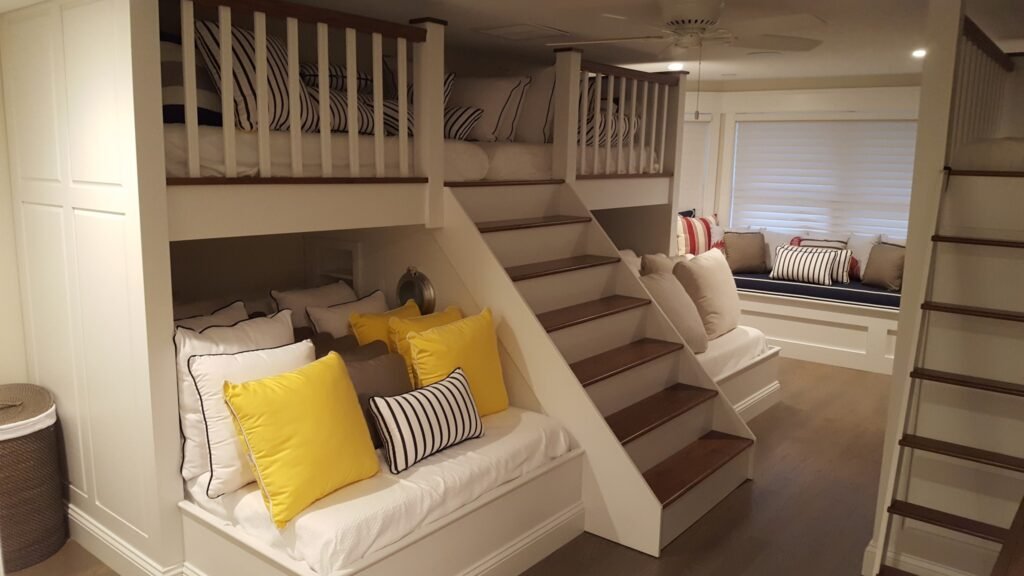 Custom built-in bunk beds with wood stairs, white cabinetry, and window bench seating by Choice Custom Cabinetry & Design in Pennsylvania.