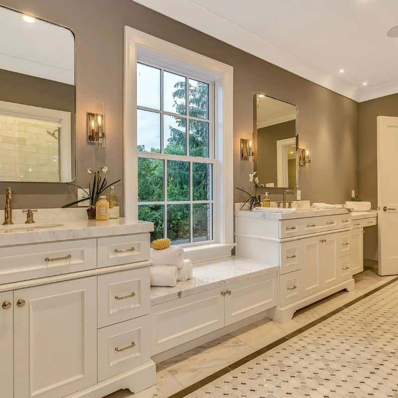 Custom white bathroom vanity cabinets with elegant marble countertops and modern lighting fixtures.