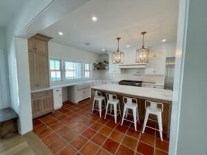 Terracotta tile kitchen with white inset cabinets and wood island